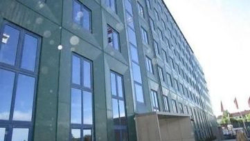 Moderne bygg med grønne plater og store vindu